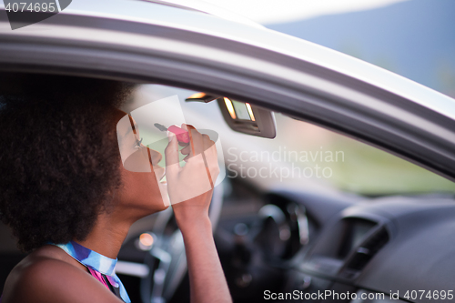 Image of a young African-American woman makeup in the car