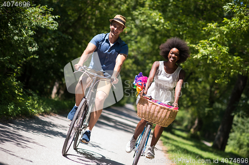 Image of Young multiethnic couple having a bike ride in nature