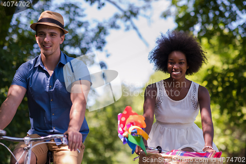 Image of Young multiethnic couple having a bike ride in nature