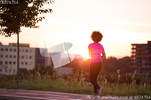 Image of a young African American woman jogging outdoors