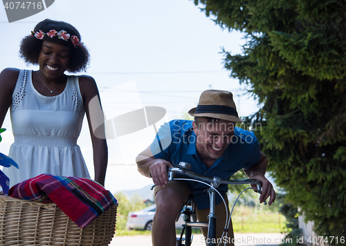 Image of Young multiethnic couple having a bike ride in nature