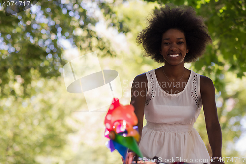 Image of pretty young african american woman riding a bike in forest