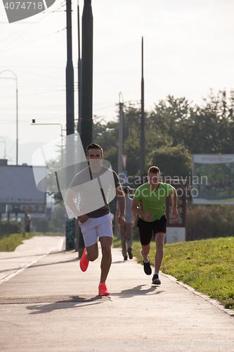 Image of Two young men jogging through the city