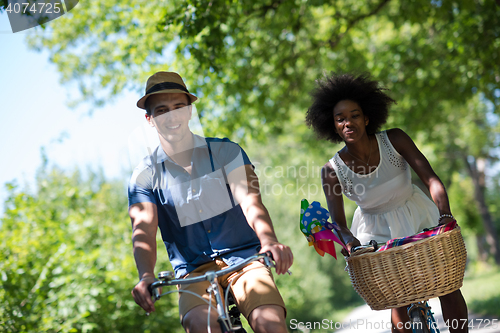 Image of Young multiethnic couple having a bike ride in nature