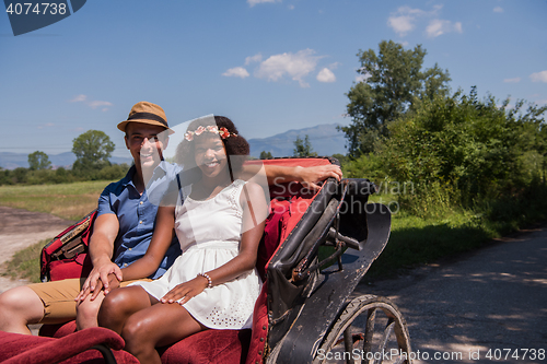 Image of multiethnic couple sitting in a horse carriage