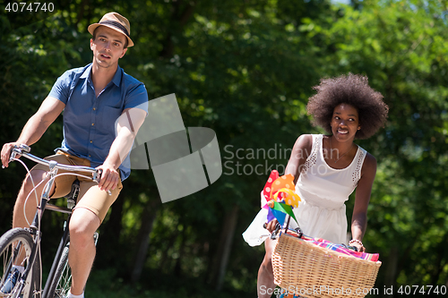 Image of Young multiethnic couple having a bike ride in nature