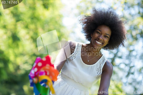 Image of pretty young african american woman riding a bike in forest