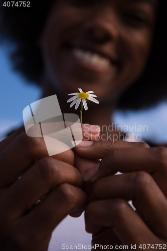 Image of portrait of African American girl with a flower in her hand