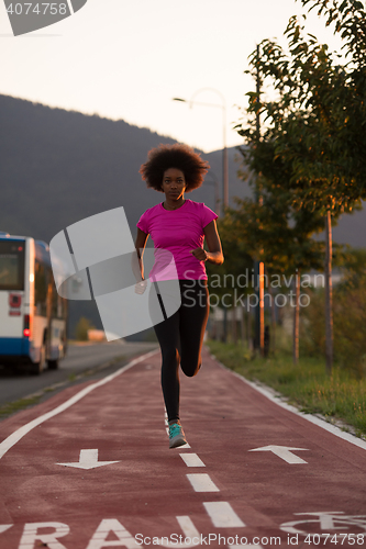 Image of a young African American woman jogging outdoors