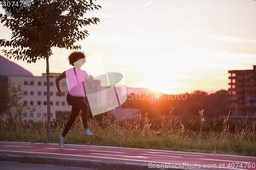 Image of a young African American woman jogging outdoors