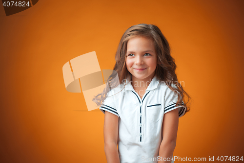 Image of The cute cheerful little girl on orange background