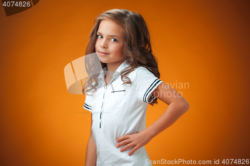 Image of The cute cheerful little girl on orange background