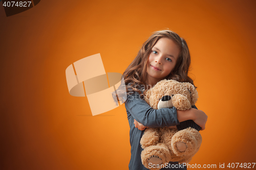 Image of The cute cheerful little girl on orange background