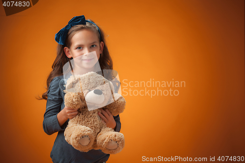 Image of The cute cheerful little girl on orange background