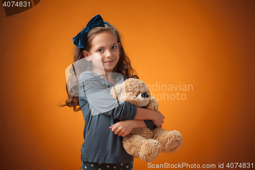 Image of The cute cheerful little girl on orange background