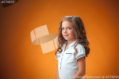 Image of The cute cheerful little girl on orange background