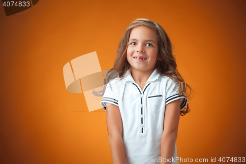 Image of The cute cheerful little girl on orange background