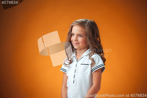 Image of The cute cheerful little girl on orange background