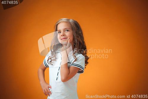 Image of The cute cheerful little girl on orange background