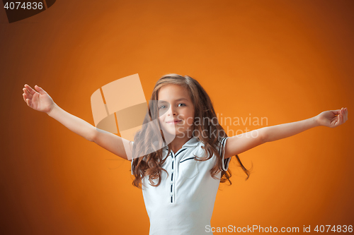 Image of The cute cheerful little girl on orange background