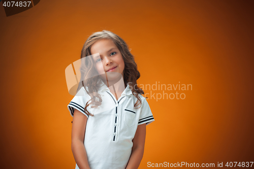 Image of The cute cheerful little girl on orange background