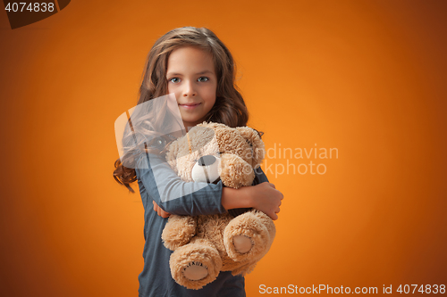 Image of The cute cheerful little girl on orange background