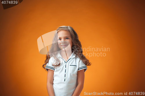 Image of The cute cheerful little girl on orange background