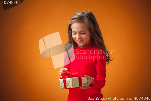 Image of The cute cheerful little girl on orange background