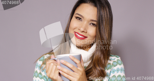 Image of Attractive woman enjoying a hot beverage