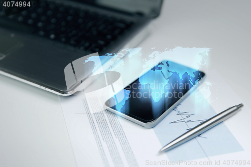 Image of close up of smartphone with world map hologram