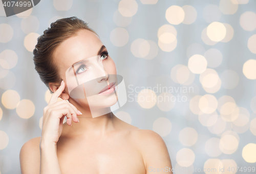 Image of beautiful woman looking up over holidays lights