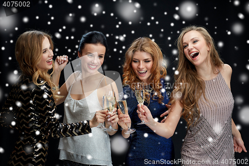 Image of happy women clinking champagne glasses over snow