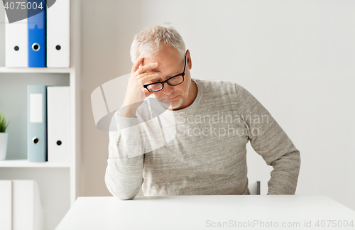 Image of senior man sitting at table