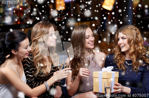 Image of happy women with champagne and gift at night club