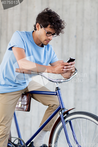 Image of man with smartphone and fixed gear bike on street