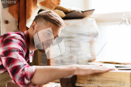 Image of carpenter working with wood plank at workshop