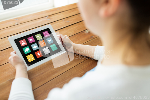 Image of close up of woman with tablet pc on wooden table