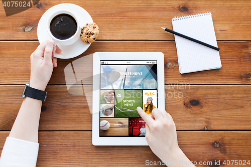 Image of close up of woman with tablet pc on wooden table