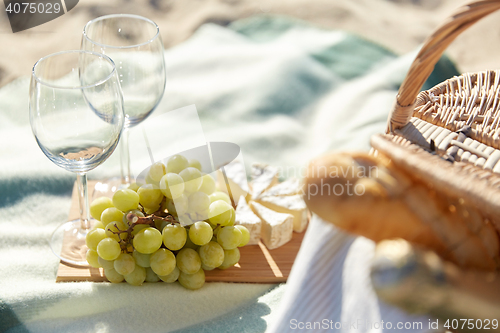 Image of picnic with wine glasses and food on beach