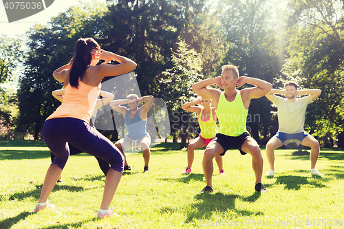 Image of group of friends or sportsmen exercising outdoors