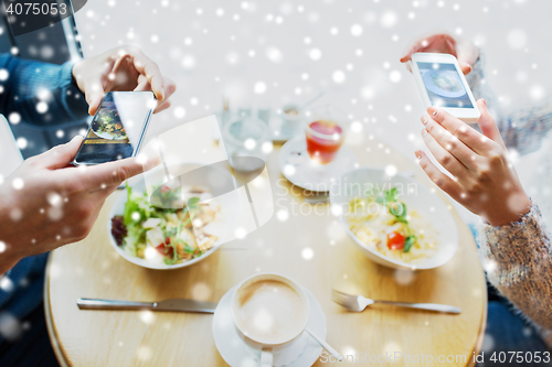 Image of close up of couple picturing food by smartphone