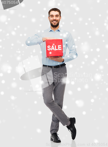 Image of smiling man with red sale sign over snow