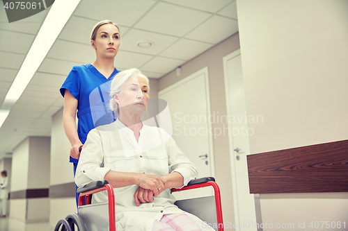 Image of nurse with senior woman in wheelchair at hospital
