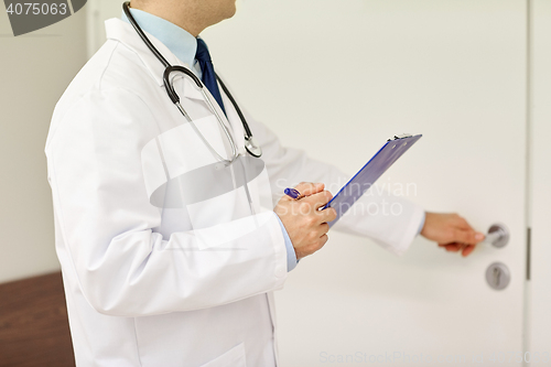 Image of close up of doctor with clipboard at hospital door