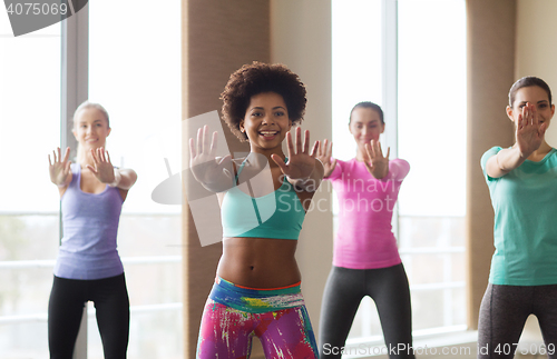 Image of group of smiling people dancing in gym or studio