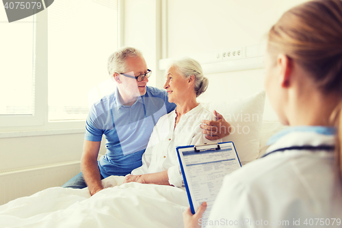 Image of senior woman and doctor with clipboard at hospital