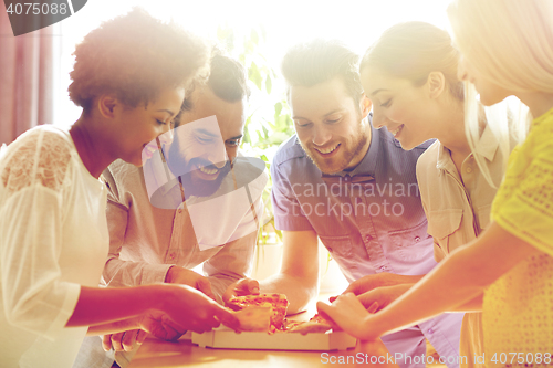 Image of happy business team eating pizza in office