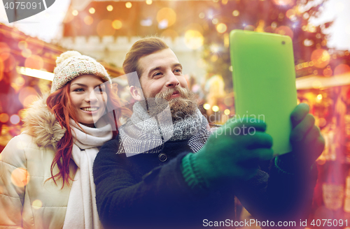 Image of couple taking selfie with tablet pc in old town