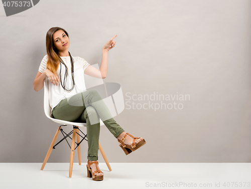 Image of Woman pointing to the wall