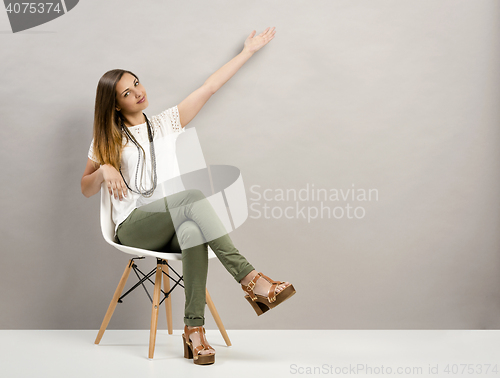 Image of Woman pointing to the wall